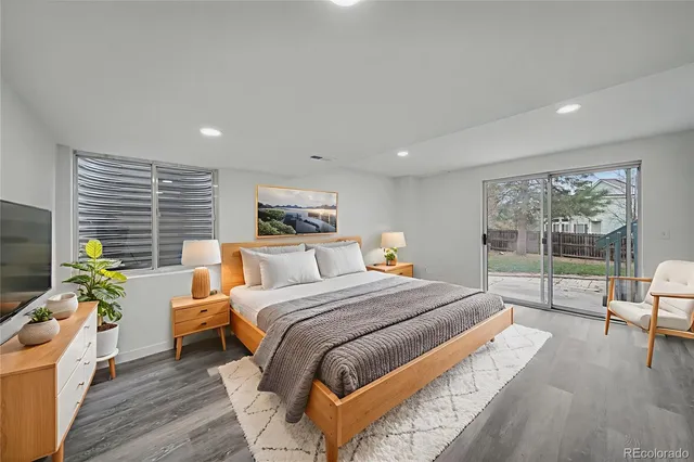 a bedroom with a bed a table and a large window