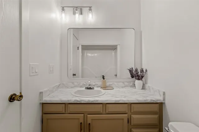 a bathroom with a granite countertop sink and a mirror