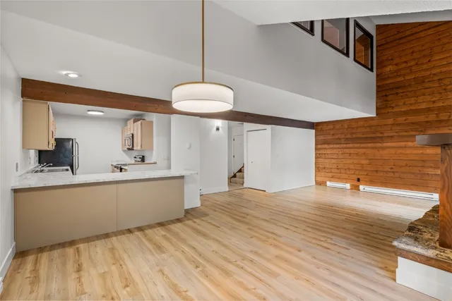 a large white kitchen with a sink and chandelier