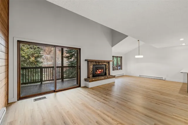 a view of a livingroom with wooden floor and a fireplace