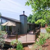 a view of a house with wooden fence next to a yard