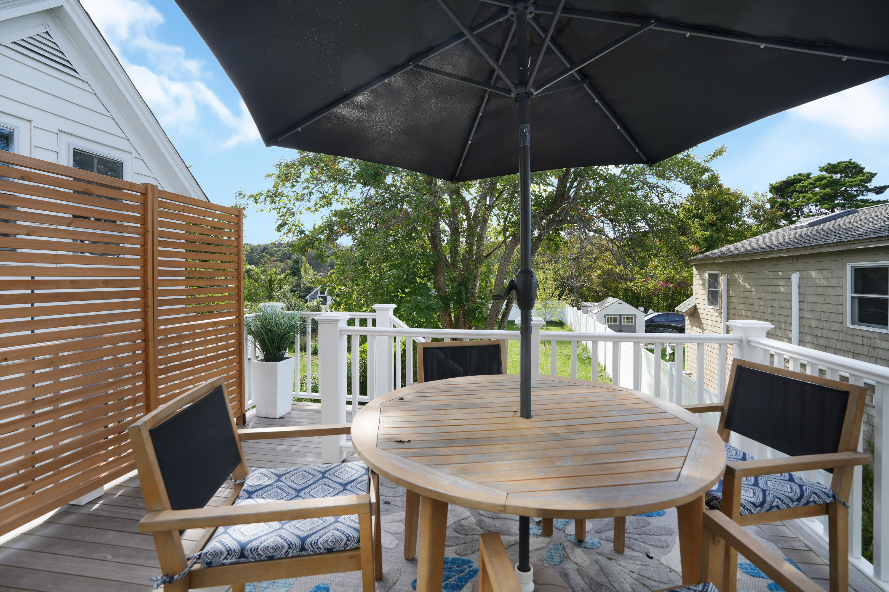 33 Lagoon Pond Road Vineyard Haven, MA 02568 - Photo 11 of 42 a view of a patio with table and chairs under an umbrella