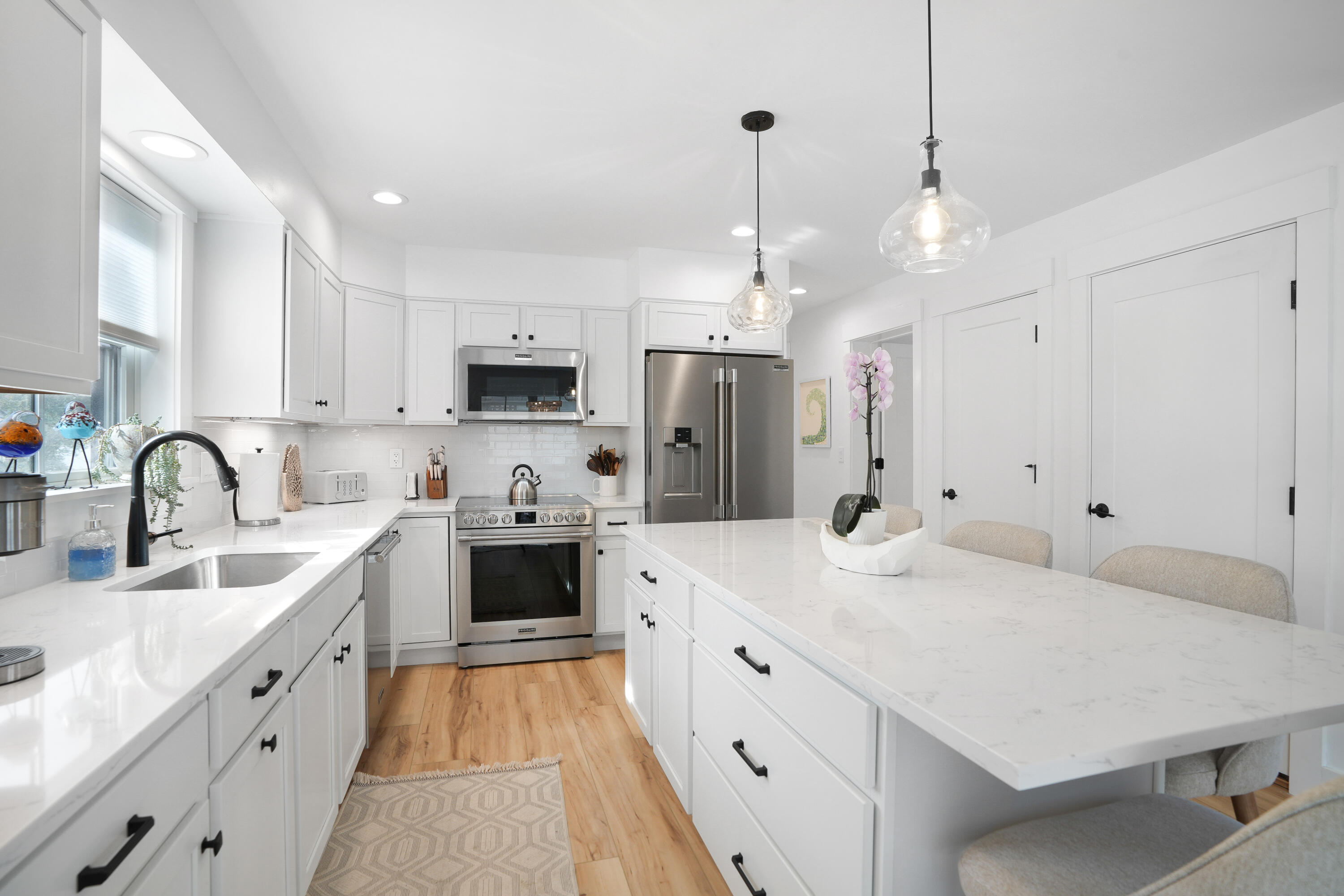 33 Lagoon Pond Road Vineyard Haven, MA 02568 - Photo 15 of 42 a large kitchen with stainless steel appliances kitchen island a white stove a sink a refrigerator and white cabinets with wooden floor
