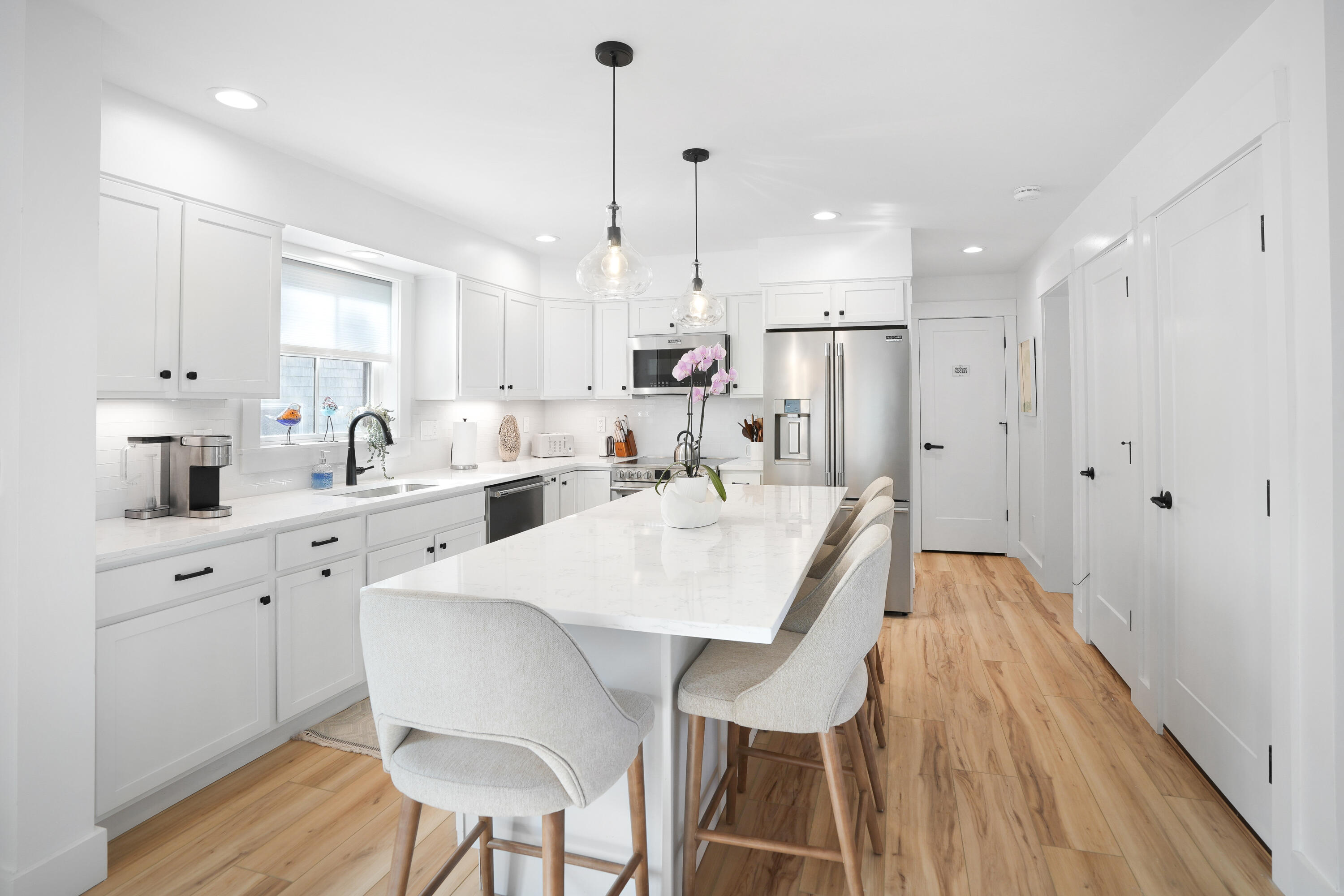 33 Lagoon Pond Road Vineyard Haven, MA 02568 - Photo 17 of 42 a large kitchen with kitchen island a dining table chairs and white cabinets