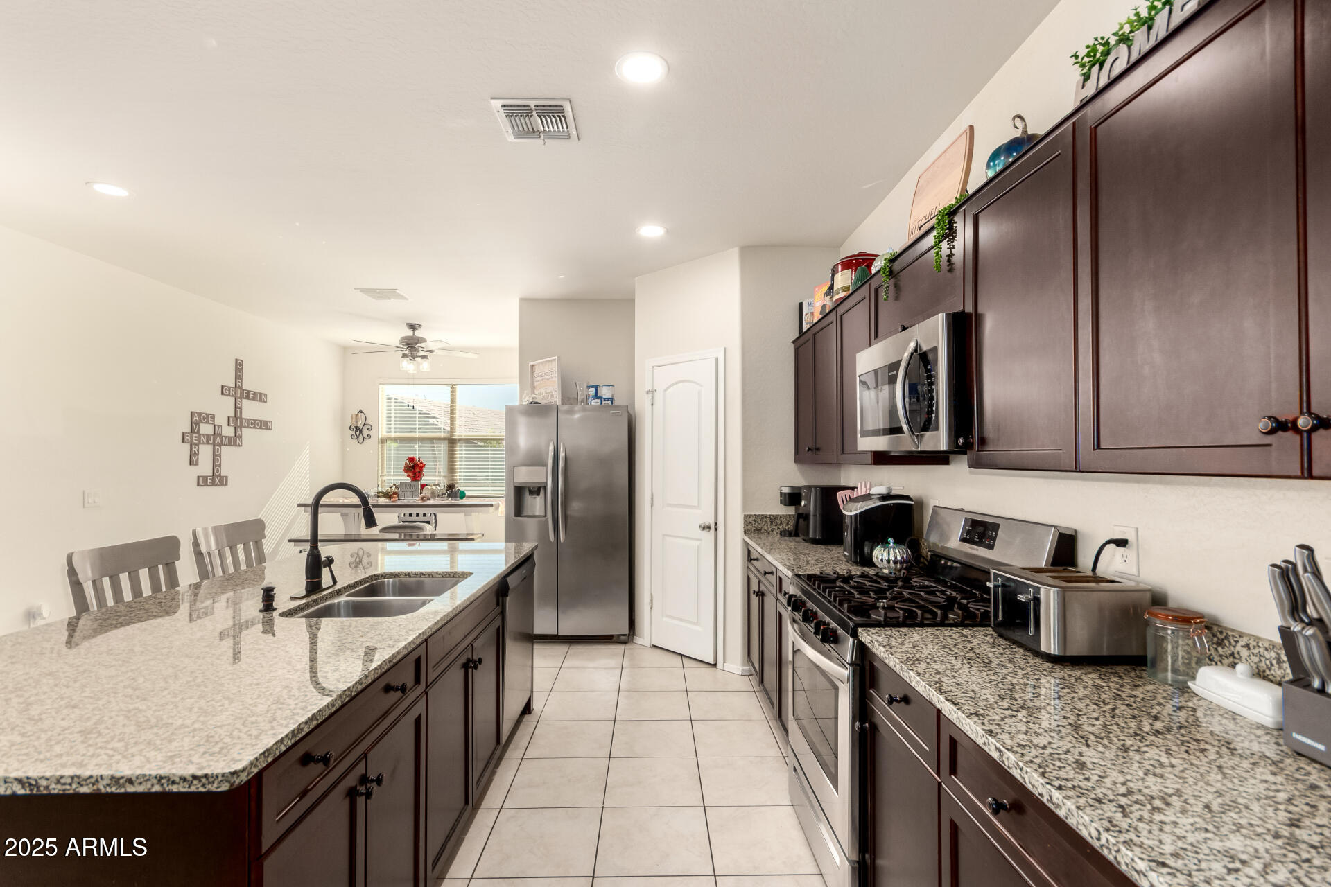 30879 West Picadilly Road Buckeye, AZ 85396 - Photo 12 of 34 a kitchen with stainless steel appliances granite countertop a sink stove and refrigerator