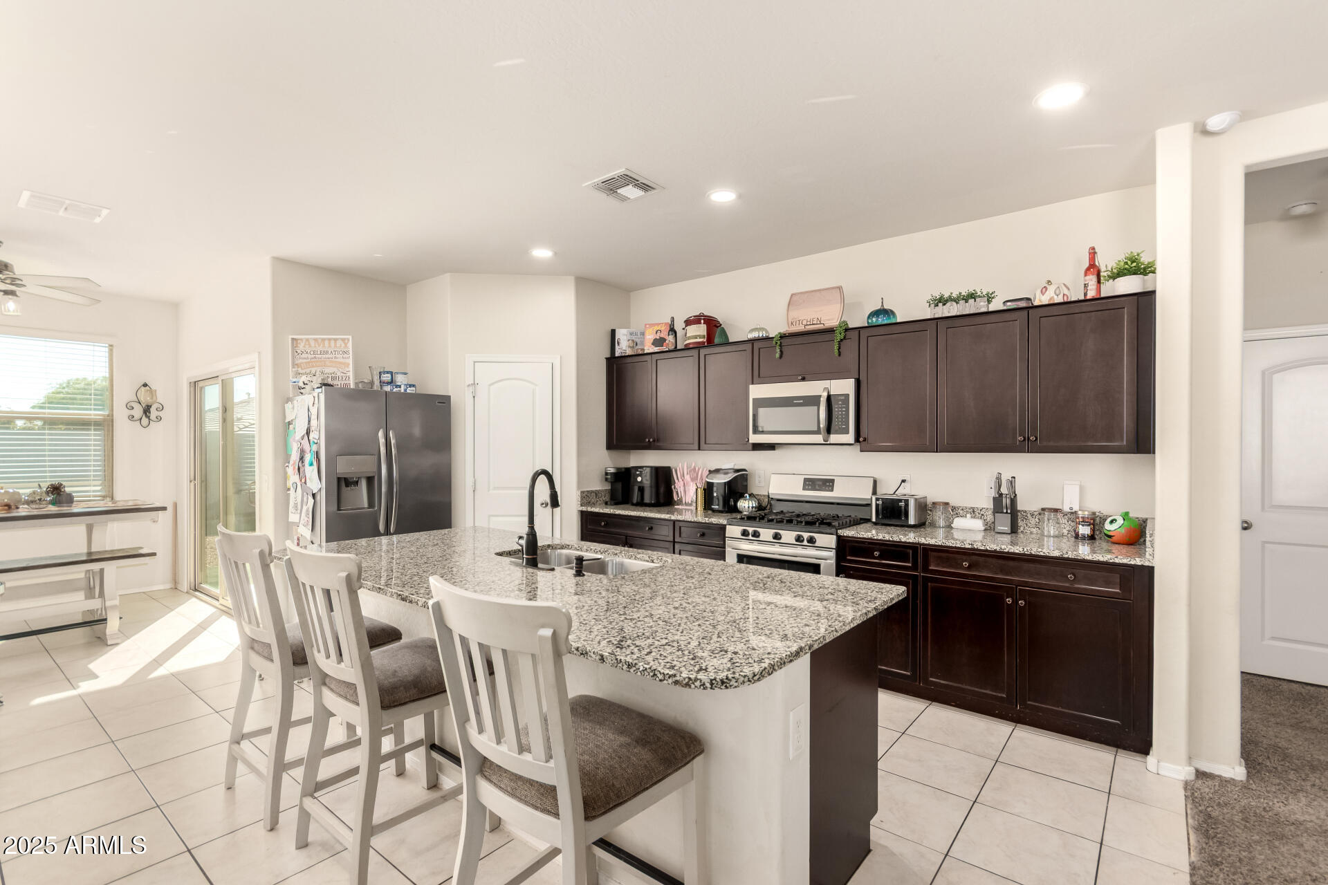 30879 West Picadilly Road Buckeye, AZ 85396 - Photo 13 of 34 a kitchen with stainless steel appliances kitchen island granite countertop a sink and cabinets