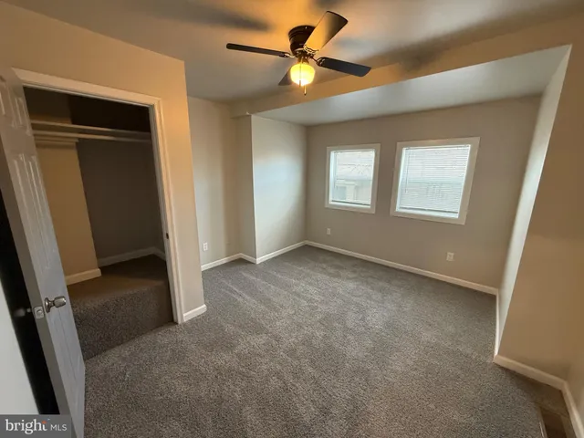 a view of a livingroom with a ceiling fan and window