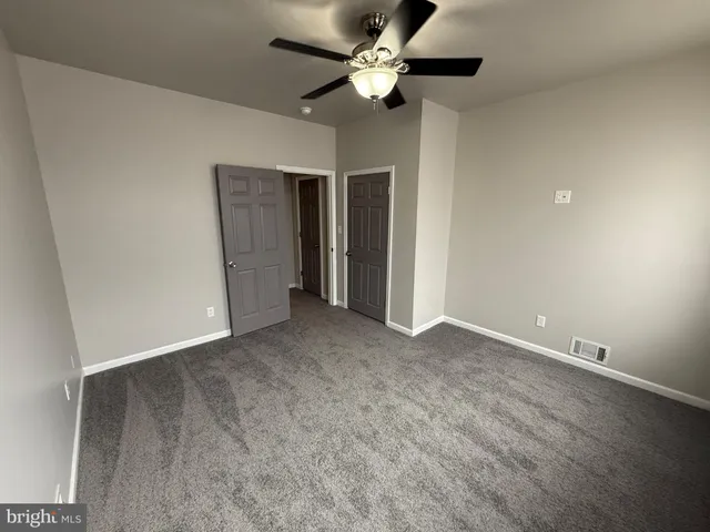 a view of an empty room with a ceiling fan
