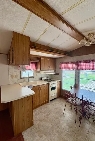 a kitchen with stainless steel appliances a sink counter top space cabinets and wooden floor