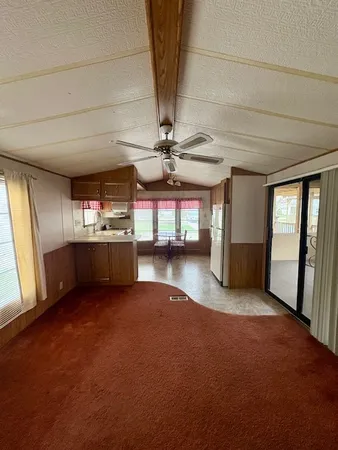 a view of a livingroom with a furniture a ceiling fan and window