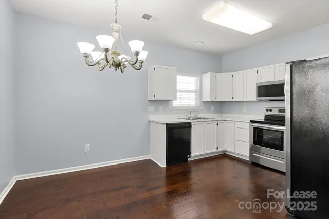a white kitchen with a stove a sink and dishwasher