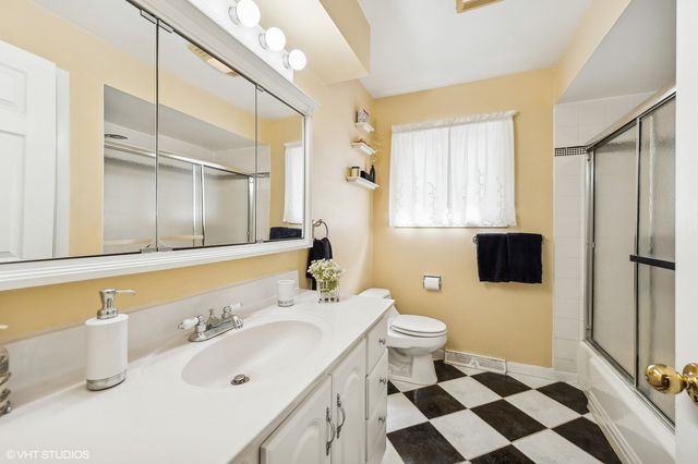 a bathroom with a sink a toilet a mirror and shower