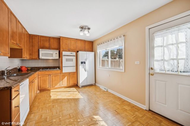 a large kitchen with stainless steel appliances granite countertop a stove a sink and a refrigerator