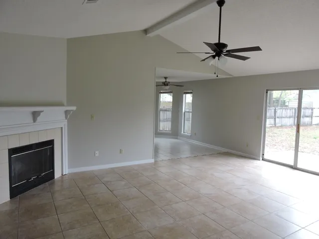 a view of an empty room with a fireplace and a window