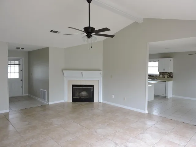 a view of a livingroom with a fireplace and a ceiling fan