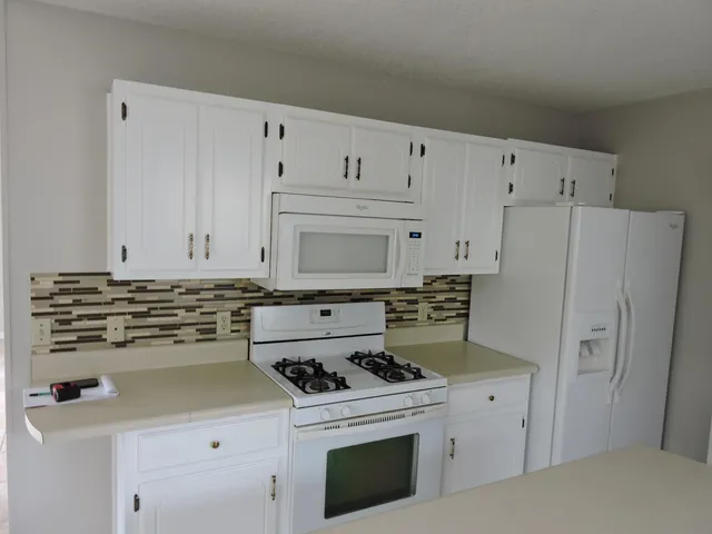 a kitchen with cabinets a stove and a refrigerator