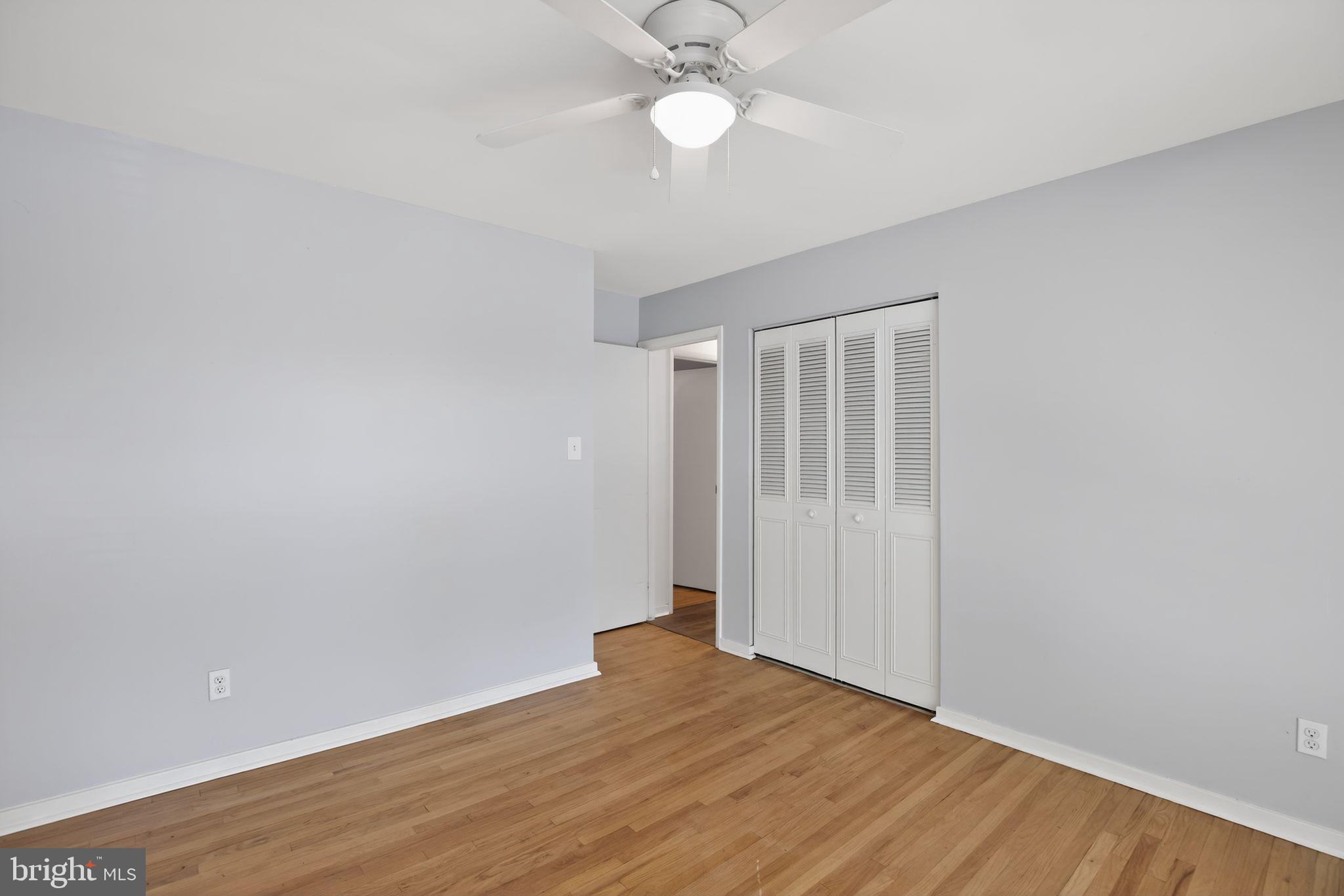 9276 Soaring Hill Road Columbia, MD 21045 - Photo 12 of 27 a view of an empty room with wooden floor and a ceiling fan