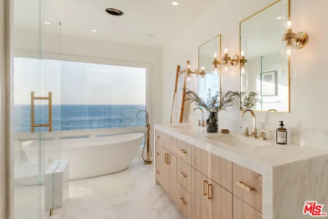 a bathroom with a double vanity sink mirror and bathtub