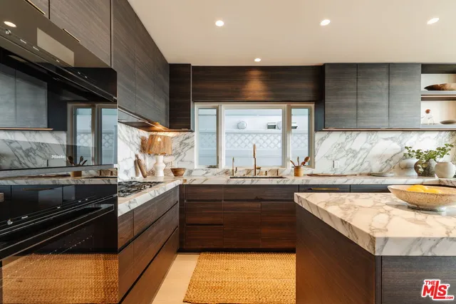 a kitchen with stainless steel appliances kitchen island granite countertop a sink and a stove