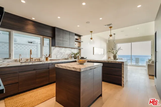 a kitchen with stainless steel appliances granite countertop a sink a stove and a wooden floors