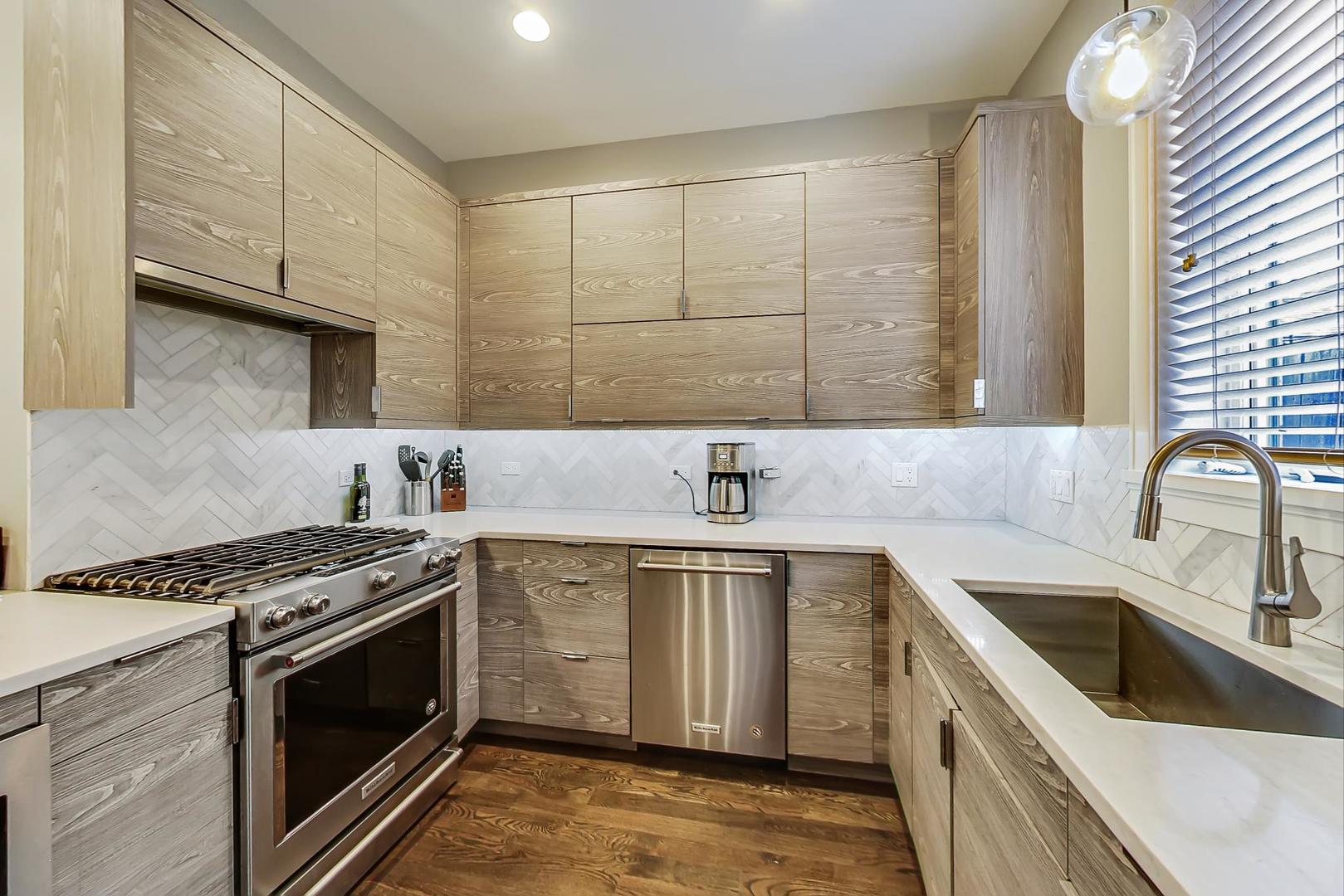 2339 North Drake Avenue Chicago, IL 60647 - Photo 7 of 29 a kitchen with stainless steel appliances granite countertop a sink stove and cabinets