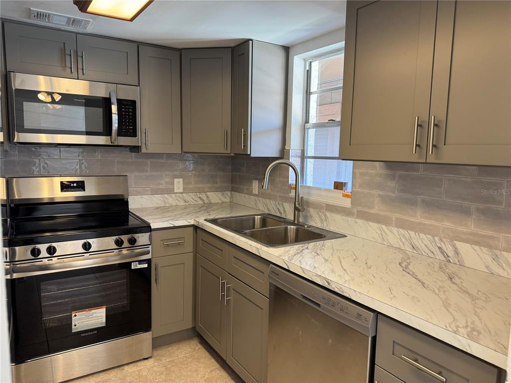 5154 Turquoise Lane, Unit 102 New Port Richey, FL 34652 - Photo 3 of 11 a kitchen with a sink stove and microwave