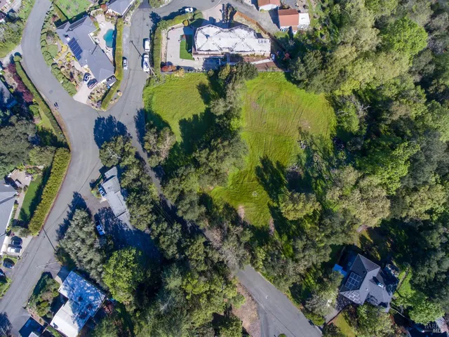 an aerial view of residential house with outdoor space and trees all around