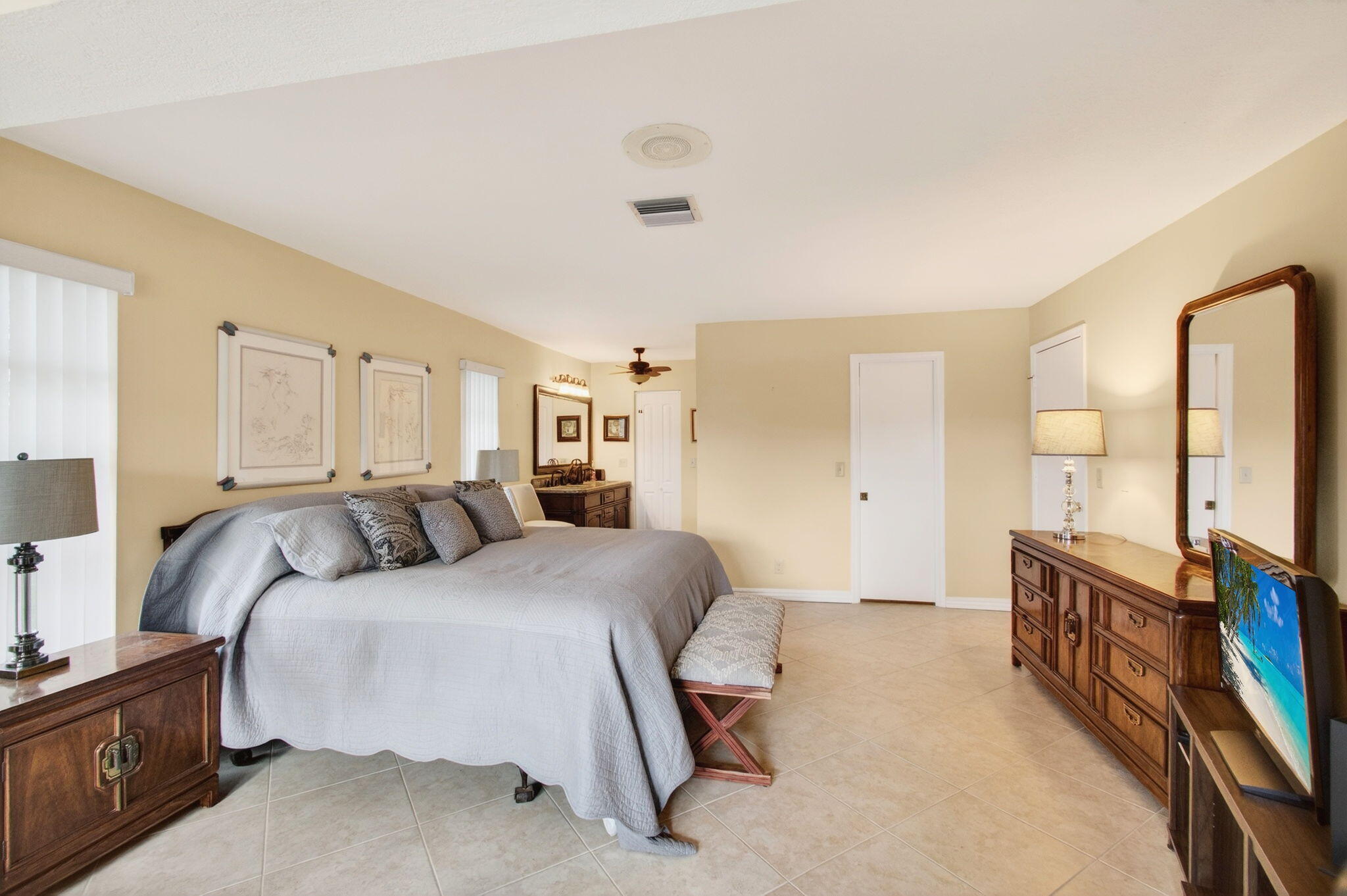 5263 Privet Place, Unit D Delray Beach, FL 33484 - Photo 24 of 60 a bedroom with a bed a mirror and desk