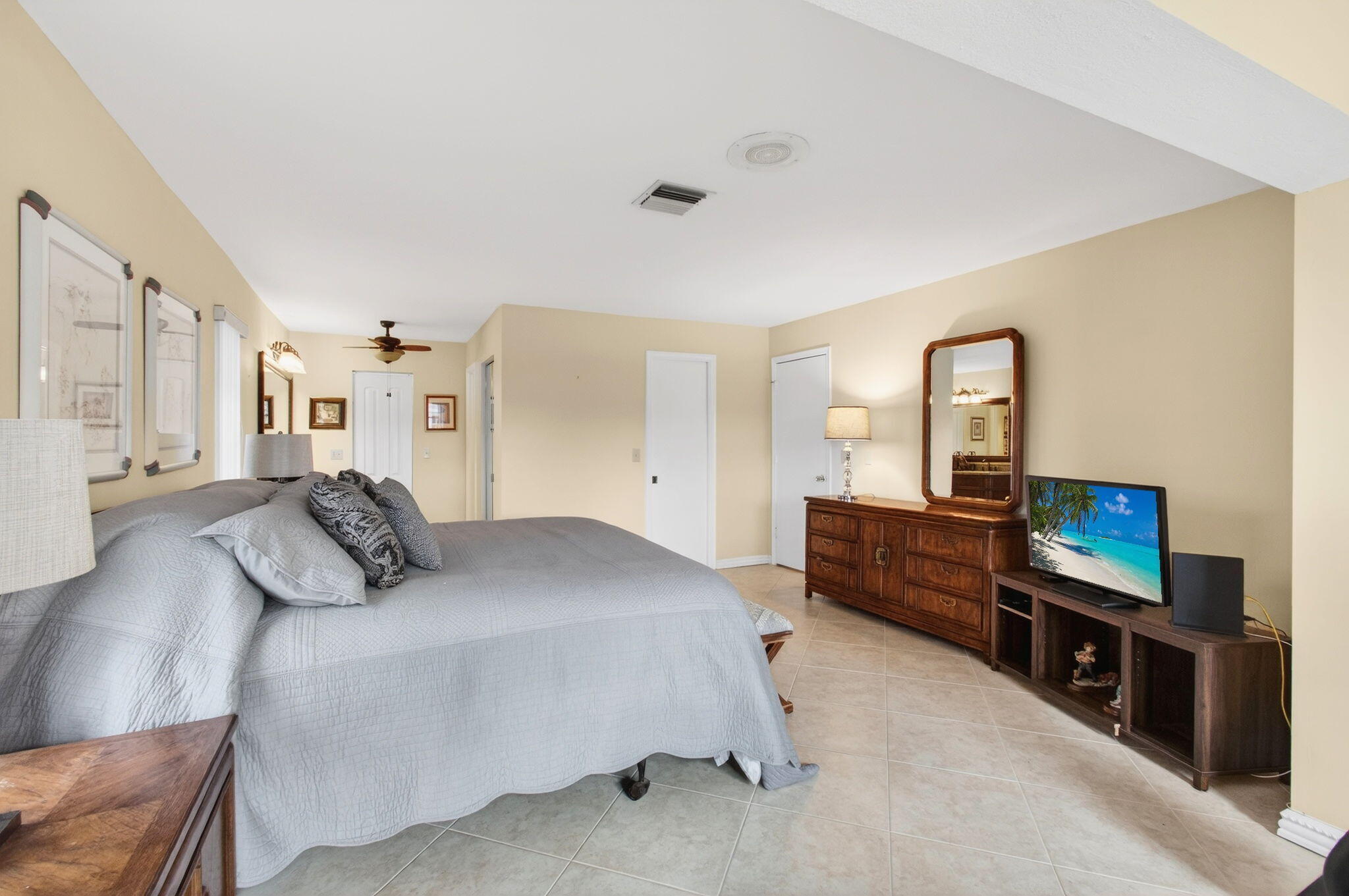 5263 Privet Place, Unit D Delray Beach, FL 33484 - Photo 25 of 60 a bedroom with a bed and a flat screen television