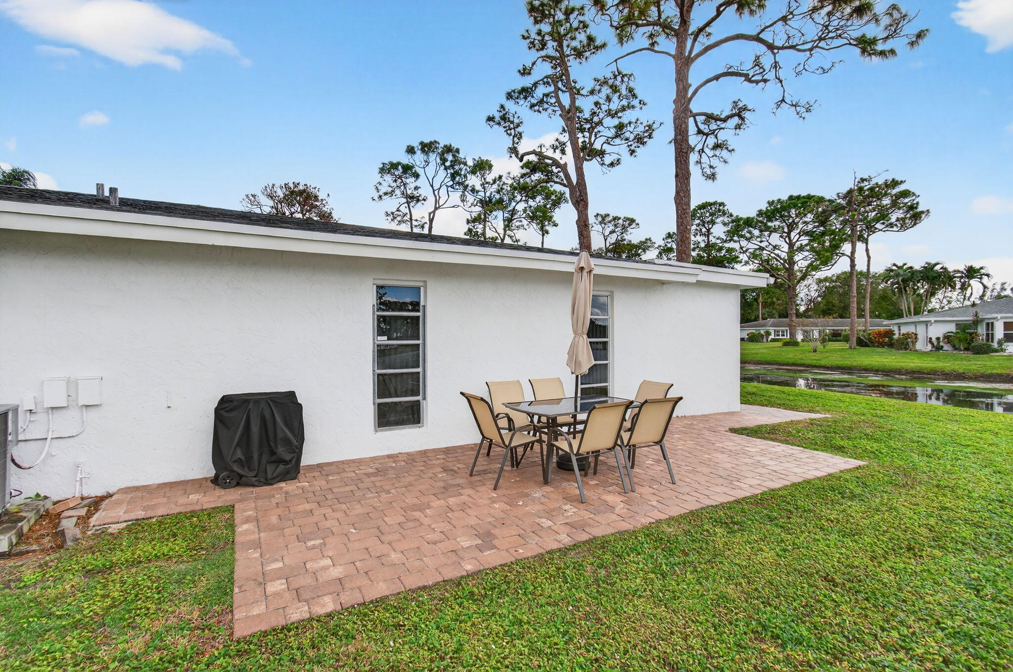 5263 Privet Place, Unit D Delray Beach, FL 33484 - Photo 37 of 60 a view of a backyard with table and chairs potted plants and a tree