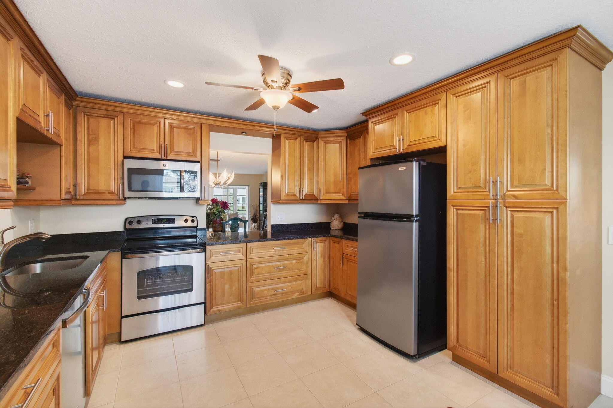 5263 Privet Place, Unit D Delray Beach, FL 33484 - Photo 4 of 60 a kitchen with granite countertop stainless steel appliances a refrigerator cabinets and a window