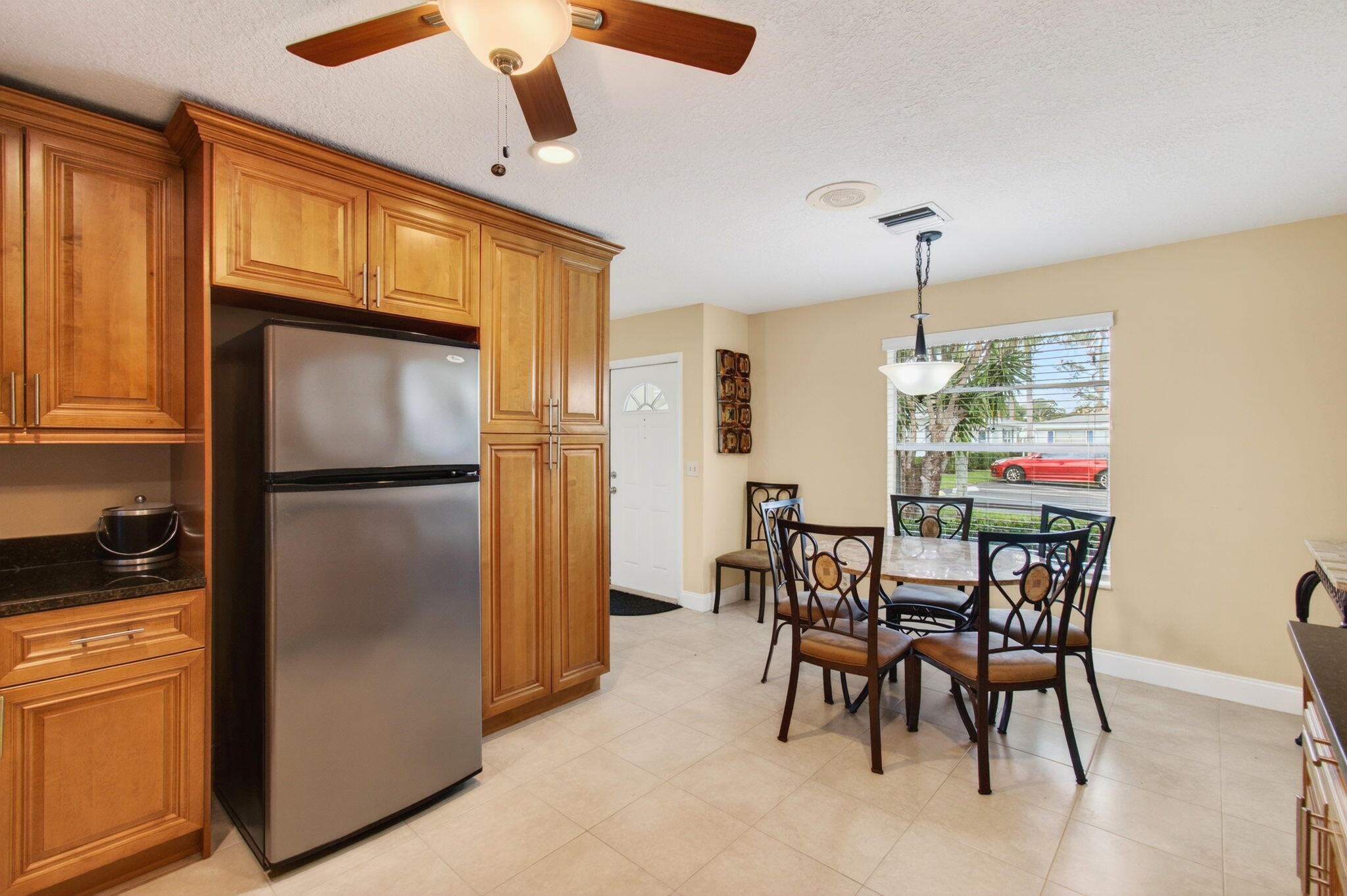 5263 Privet Place, Unit D Delray Beach, FL 33484 - Photo 7 of 60 a kitchen with stainless steel appliances granite countertop a refrigerator a stove a kitchen island with a dining table and chairs