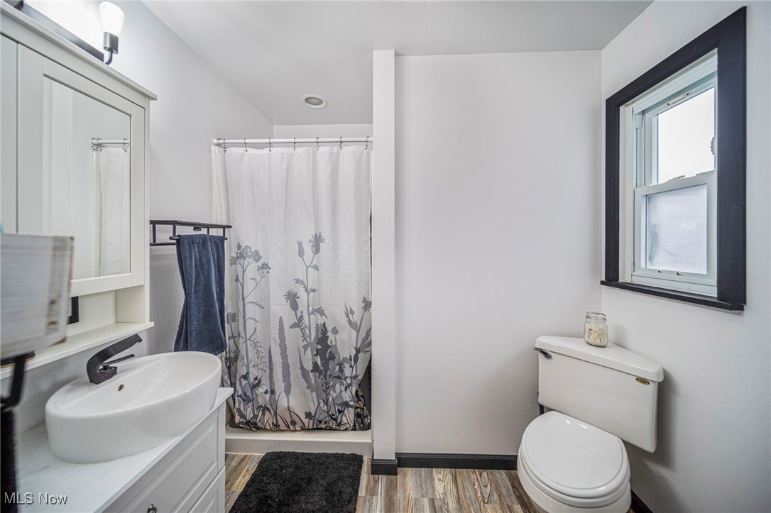 6600 Reynolds Road Mentor, OH 44060 - Photo 25 of 35 Full bathroom with vanity, wood-type flooring, toilet, and shower / bath combo with shower curtain