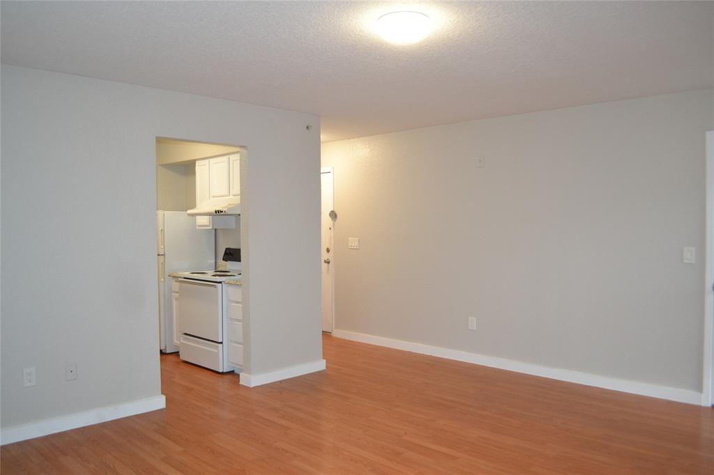 701 West Sycamore Street, Unit 207 Denton, TX 76201 - Photo 3 of 10 Unfurnished room featuring light hardwood / wood-style floors and a textured ceiling