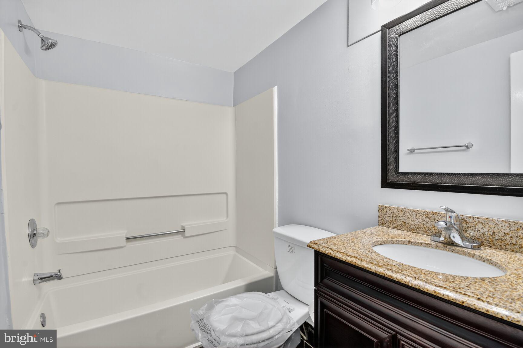 3976 Bel Pre Road, Unit 39761 Silver Spring, MD 20906 - Photo 15 of 19 a bathroom with a granite countertop toilet sink and mirror