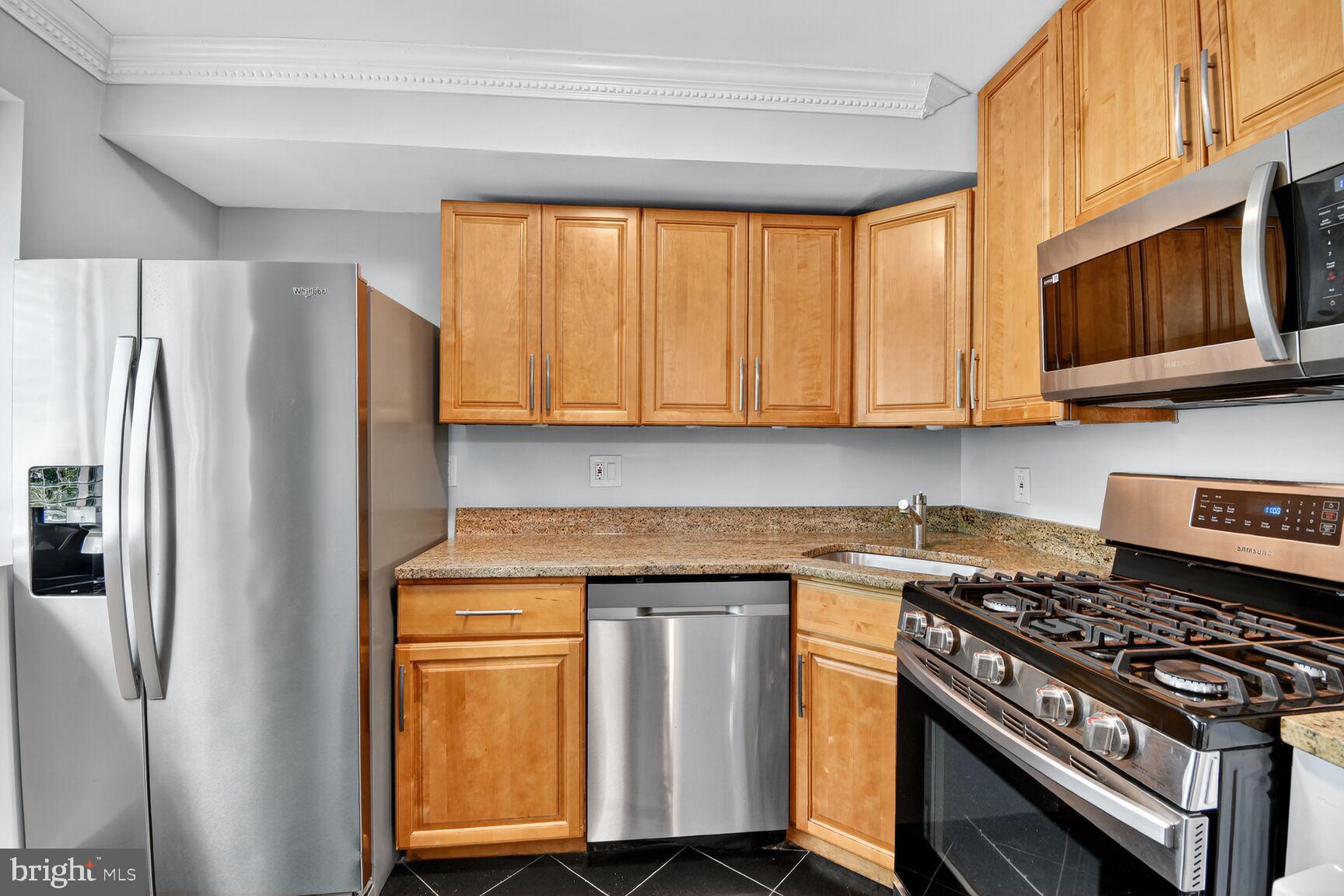 3976 Bel Pre Road, Unit 39761 Silver Spring, MD 20906 - Photo 2 of 19 a kitchen with stainless steel appliances granite countertop a stove a refrigerator and a microwave