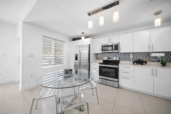 a kitchen with granite countertop a stove a sink and a refrigerator