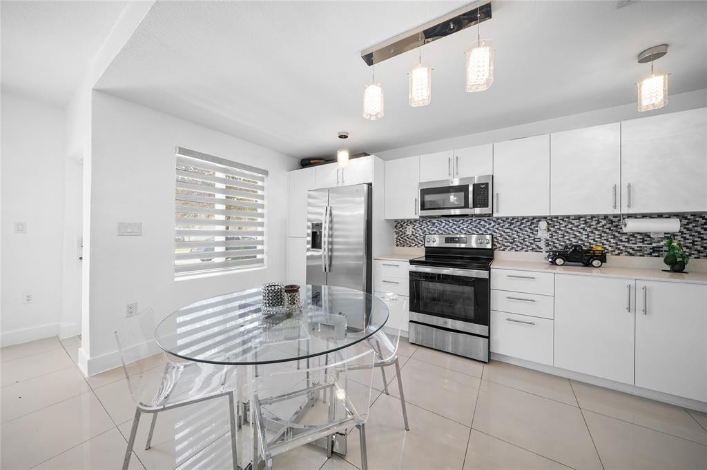 14474 Southwest 259th Street Homestead, FL 33032 - Photo 3 of 25 a kitchen with granite countertop a stove a sink and a refrigerator