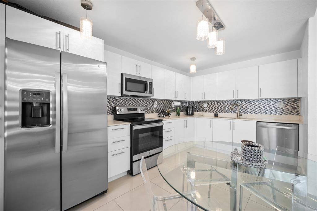 14474 Southwest 259th Street Homestead, FL 33032 - Photo 5 of 25 a kitchen with stainless steel appliances granite countertop a refrigerator a stove and a sink with wooden floor