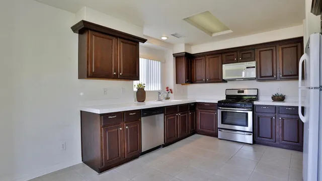 a kitchen with stainless steel appliances granite countertop a stove sink and cabinets