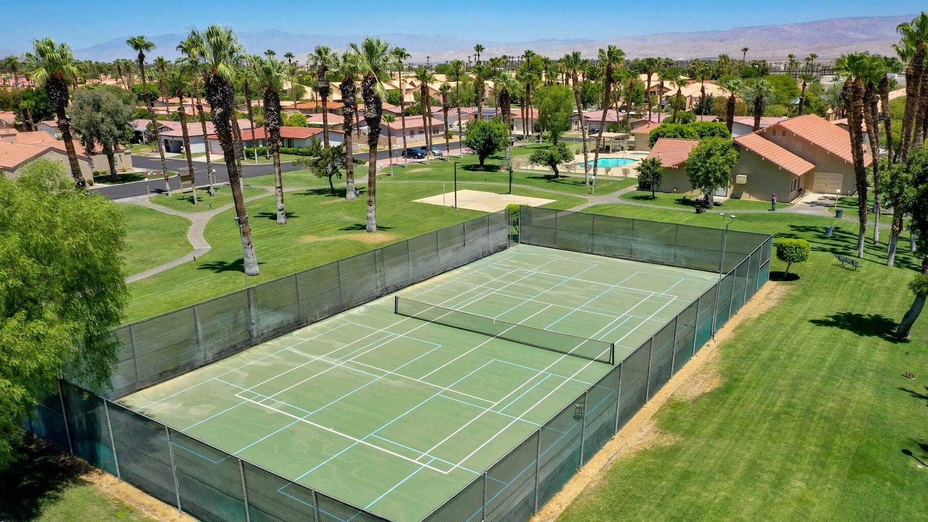 77861 Villa Road Palm Desert, CA 92211 - Photo 17 of 24 a view of a tennis ground with large trees