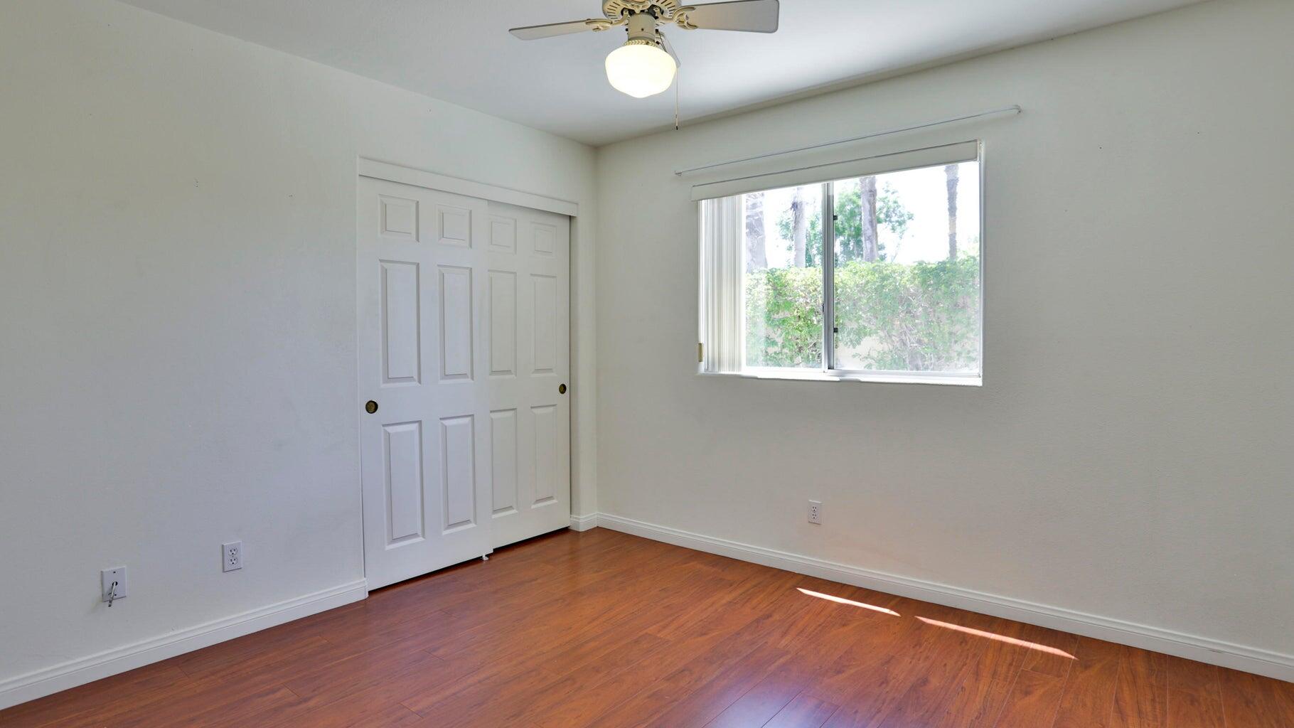 77861 Villa Road Palm Desert, CA 92211 - Photo 23 of 24 an empty room with wooden floor and windows