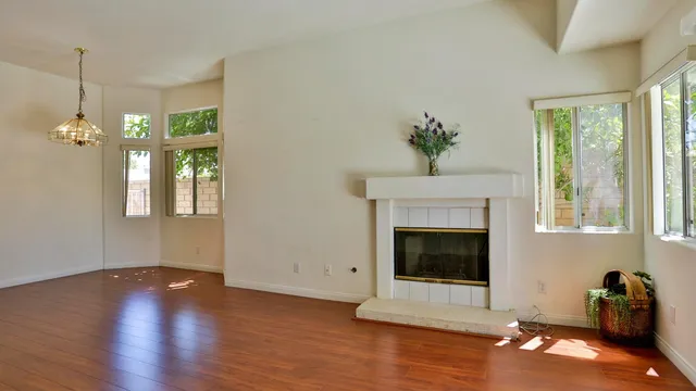 a living room with hardwood floor a fireplace and window