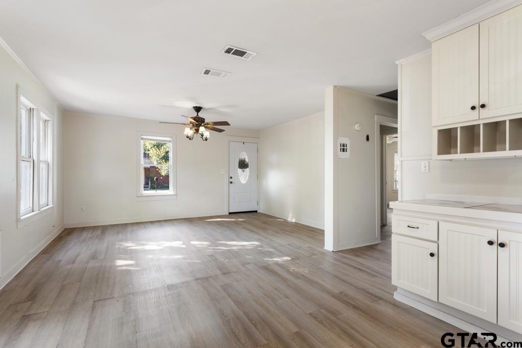 107 Mallory Street Lindale, TX 75771 - Photo 14 of 33 an empty room with wooden floor cabinet and windows