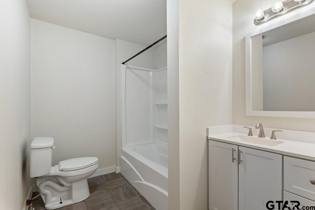 107 Mallory Street Lindale, TX 75771 - Photo 28 of 33 a bathroom with a granite countertop sink a toilet and shower