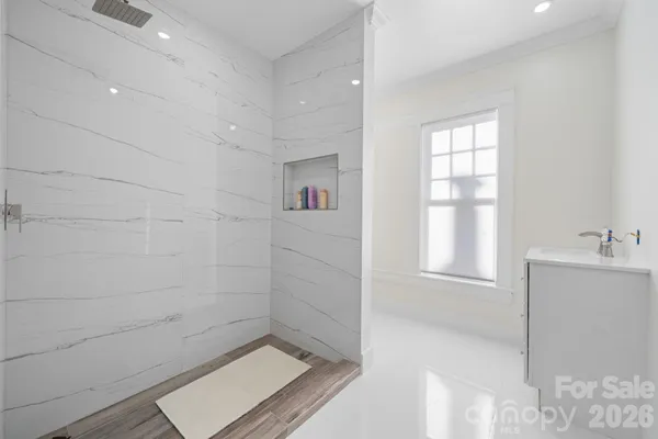 a bathroom with a sink a window and shower