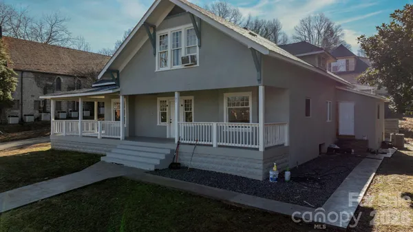 a view of a house with a small yard and wooden floor and fence