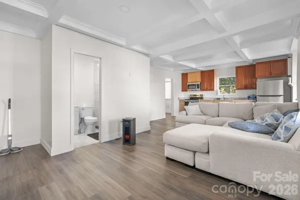 a living room with furniture and a wooden floor