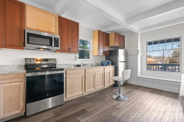 a kitchen with stainless steel appliances a stove a sink cabinets and a window