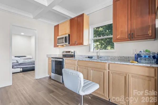 a kitchen with stainless steel appliances granite countertop a stove a sink dishwasher and microwave with wooden floor